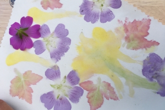 A printing with pink and yellow flowers and red and green leaves