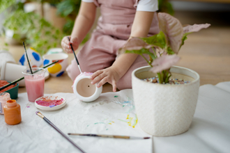 Child painting flower pot