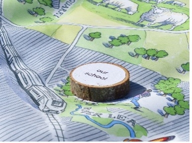 Tree slice with text 'our school', sitting on a map