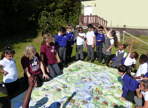 Children gathered around a map learning about their local landscape in Beds