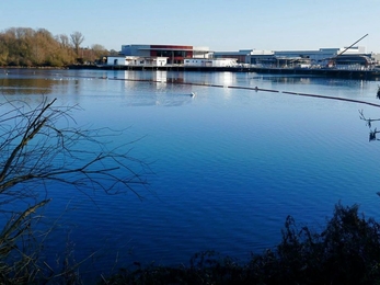 The Nene Wetlands Visitor Centre in winter 2016 against a bright blue sky from across the lake