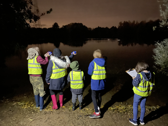 A Wildlife Watch group using bat detectors by the lake