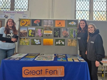 Photography stall display, interns amd staff member smiling at the camera