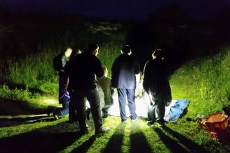 People gathered around a bright light at night