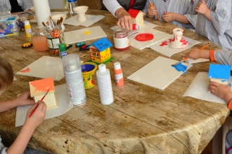 Children sitting around a craft table painting