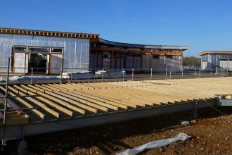 The Visitor Centre taking shape with silver cladding against a bright blue sky