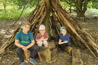 Children in a den at Ramsey Heights nature reserve