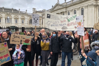 A group of Wildlife Trust BCN staff stand in Cambridge with banners at COP26