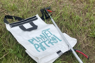 Planet Patrol bag and litter picker on grass