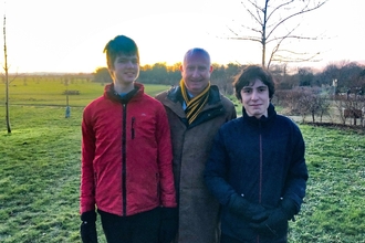 Two members of the Young Peoples Forum, standing in a frosty field with Daniel Zeichner MP, all smiling at the camera