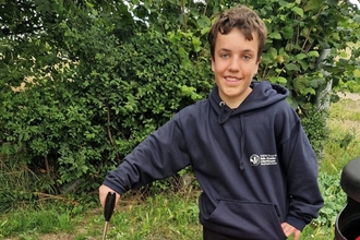 YPF member outside litter picking, smiling toward the camera