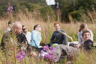 Adults enjoying a picnic in a meadow by Katrina Martin 2020VISION