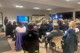Flora Guardians thank you event attendees sat in a room watching a presentation