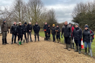 Muchwood tree planting team photograph, lots of people wrapped up warm smiling at the camera
