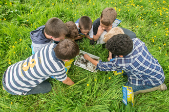 Children around a white tray by Ross Hoddinott/2020VISION