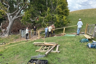 A group of people work on fixing a fence
