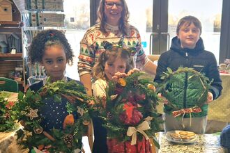 2 children holding wreaths
