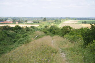 A narrow chalky path wends across the top of a dyke