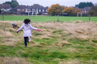 A young girl running into a field