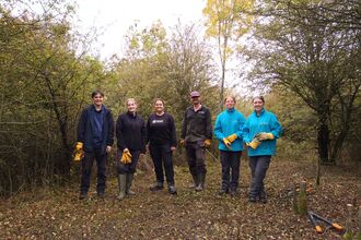 6 people standing infront of trees and shrubs