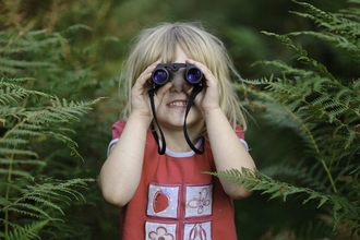 Young girl looking through binoculars