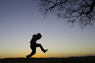 Young boy silhouetted at dusk