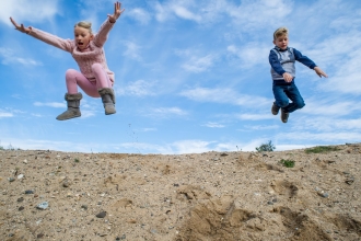 Children jumping in a blue sky