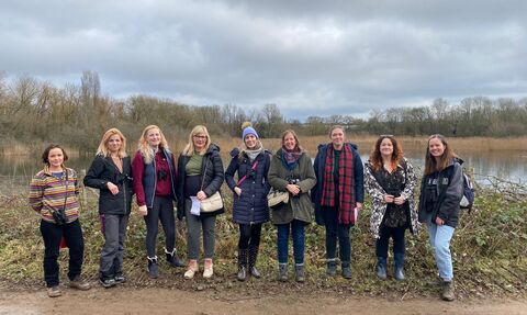 Group of women standing next to a lake