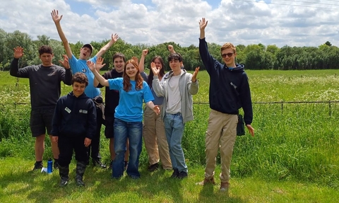 Young People's Forum smiling towards the camera and waving arms