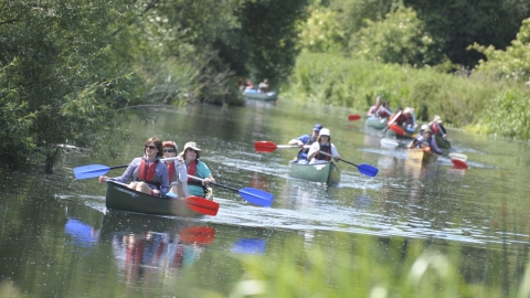 A group of people set off on canoes on the river Nene