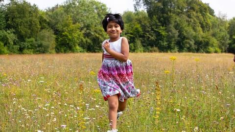 Child running through meadow by Jon Hawkins - Surrey Hills Photography