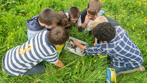 Children around a white tray by Ross Hoddinott/2020VISION