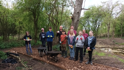 Group of young volunteers stand with Wildlife Trust staff on a newly laid path