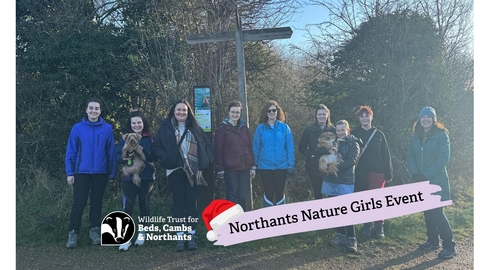 Group of people standing in front of outdoor signpost
