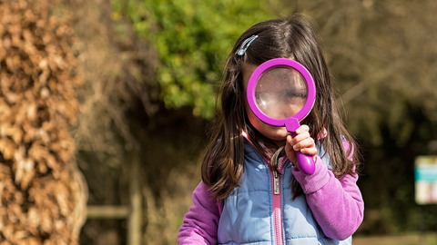 Child with magnifying glass
