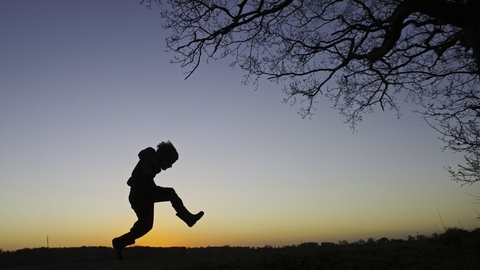 Young boy silhouetted at dusk