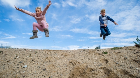 Children jumping in a blue sky