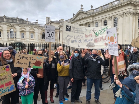 A group of Wildlife Trust BCN staff stand in Cambridge with banners at COP26