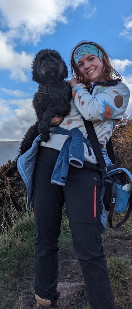 Kim Dunn smiles at the camera holding a black dog