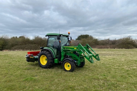 Green tractor in a field on a cloudy day