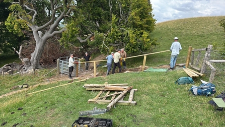 A group of people work on fixing a fence