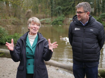 South Cambs MP Pippa Heylings talks, gesturing with her hands while standing in front of a chalk stream