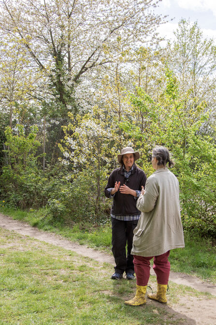 Two women, standing in the spring sunshine, chatting