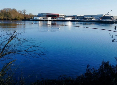 The Nene Wetlands Visitor Centre in winter 2016 against a bright blue sky from across the lake