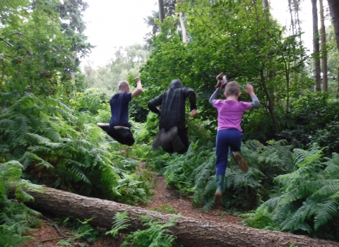 Children jumping off a log by Rebecca Neal