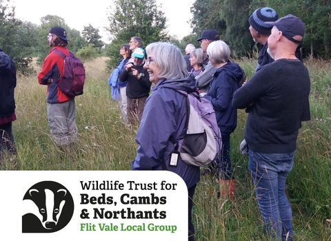 Group of people smiling, enjoying a guided walk in a field