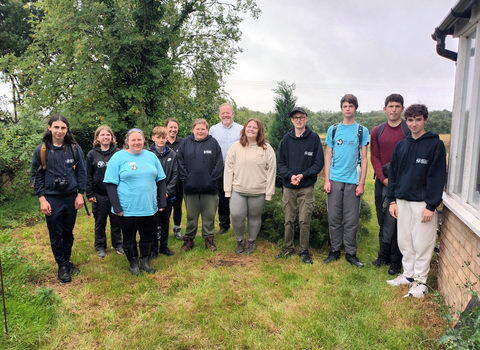 Young People's Forum members and members of staff, standing in the garden at Strawberry Hill