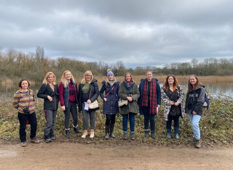 Group of women standing next to a lake