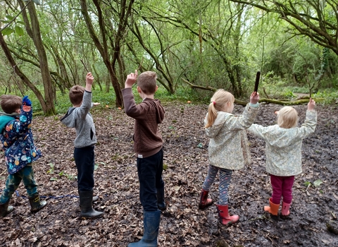 Children with sticks in Oaks Wood Cambourne Nature Reserve by Rebecca Neal
