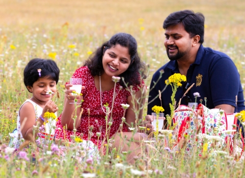 Family picnicking in wildflowers